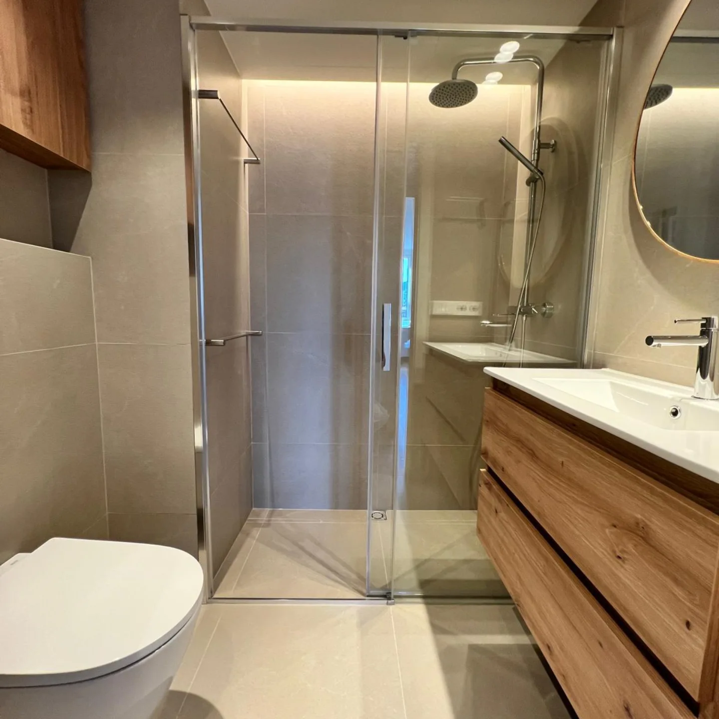 Baño reformado con ducha, mampara y mueble suspendido